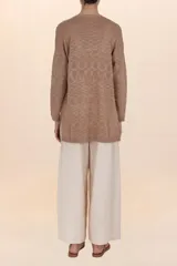 Cardigan largo marrón de tejido ligero, con diseño abierto y holgado, bolsillos frontales y botones decorativos en los costados.