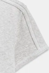 Camiseta de manga corta gris melange con cuello redondo y costuras decorativas visibles en los hombros.