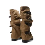Bota de caña alta slouchy confeccionada en material símil gamuza color tostado, con diseño arrugado y múltiples tiras con hebillas metálicas en el lateral. Cuenta con taco bajo y suela negra.
