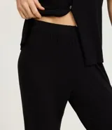 Conjunto de pijama femenino de dos piezas, compuesto por una blusa de manga corta con detalle de encaje en mangas y cuello, abotonada al frente, y un pantalón capri. Ambas prendas son de viscosa certificada.