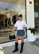 Bota texana de caña alta en color negro, con diseño de costuras decorativas en el cuerpo de la bota, punta fina y taco cuadrado.