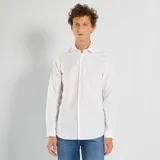 Camisa blanca de corte recto, manga larga y cuello clásico.