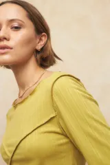 Remera negra de manga tres cuartos, escote redondo y detalle de costuras superpuestas de forma asimétrica.