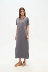 Vestido midi de corte holgado, color negro, con mangas cortas, cuello en V y detalle de cuentas decorativas en el escote.