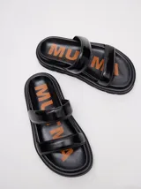 Sandalias de cuero vacuno color marrón con acabado brillante, diseño de dos tiras anchas acolchadas y plataforma baja.
