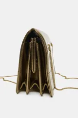 Bolso de hombro de formato rígido en piel metalizada color dorado. Presenta un diseño con pespuntes decorativos, triple compartimento interno y cierre principal mediante imán. Incluye doble asa de hombro en cadena metálica.