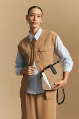 Cartera estructurada de símil cuero con diseño de bloques de color: principal en color camel, laterales en blanco y solapa frontal en negro. Posee correa larga regulable y desmontable.