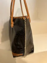 Bolso shopper de cuero azul con textura crocco, manijas largas marrones y costuras artesanales visibles en los bordes.