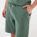 Bermuda de punto grueso color verde militar, con diseño liso y corte recto.