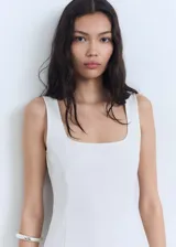 Vestido corto entallado de color blanco, con cuello cuadrado y tirantes anchos. Presenta un diseño minimalista con pinzas que definen la silueta.