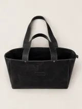 Bolso tipo tote grande de cuero negro con acabado texturizado, cierre superior, doble asa de hombro y parche con logo de la marca en el frente.