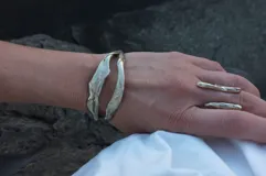 Anillo plateado con diseño abstracto y abierto, realizado en alpaca.