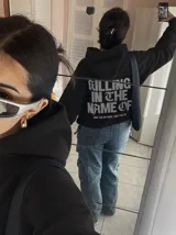 Canguro negro con capucha y bolsillo tipo canguro, de corte regular y confección en mezcla de algodón y poliéster. En la parte posterior presenta una estampa grande en tono gris con la inscripción "Killing in the name of" y una frase complementaria.