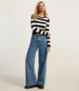 Blusa corta de tejido de punto a rayas horizontales color verde y blanco, de mangas largas y cuello redondo.