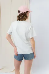 Gorra verde militar de diseño clásico con visera curva y aplique metálico plateado con la inscripción "Peach" en el lateral frontal. Cuenta con tira ajustable en la parte trasera.