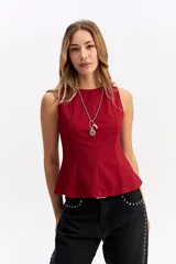 Musculosa de corte evasé, entallada en el torso con una leve amplitud en la base. Presenta cuello redondo y diseño sin mangas, confeccionada en una tela con estructura y caída.