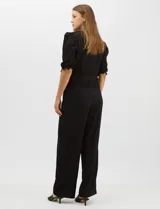 Blusa de algodón semitransparente con diseño floral bordado a tono. Presenta escote en V, cierre frontal con botones y mangas al codo ligeramente abullonadas. Incluye detalles de encaje calado estilo macramé en los puños y en el ruedo con terminaciones en ondas.
