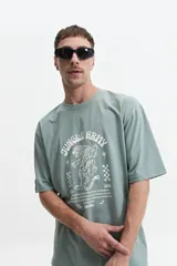 Remera color rosa claro de corte oversize con cuello redondo y mangas cortas. Estampado frontal con un tigre, estrellas y texto "Jungle Army".