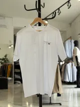 Remera oversize blanca de manga corta con estampado tipográfico y gráfico en la espalda.