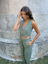 Pantalón verde de lino de corte recto con bolsillos laterales y cierre frontal con botón.