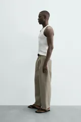 Camiseta tipo tank (sin mangas) de corte relaxed fit, color blanco, con cuello redondo y un pequeño estampado gráfico en el pecho que dice "SANTA BARBARA EST. 1987 CALIFORNIA".