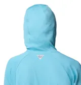 Remera de manga larga con capucha Columbia, confeccionada en tejido técnico transpirable con tecnología Omni-Wick y protección solar Omni-Shade UPF 40. Presenta diseño de corte recto, capucha cruzada, orificios para los pulgares en los puños y logo estampado en el pecho y en la manga.