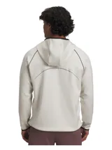 Buzo deportivo Under Armour de media cremallera, color beige con detalles en negro en el borde de la capucha y puños. Presenta bolsillos laterales con cierre y diseño ergonómico para mayor libertad de movimiento.