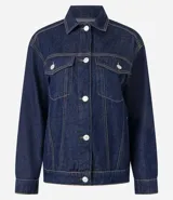 Campera trucker de jeans azul oscuro, corte amplio, con cuello clásico, cierre frontal con botones blancos, mangas largas y bolsillos delanteros con solapa.