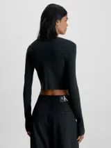 Sweater cárdigan de corte cropped y ajuste slim, confeccionado en tejido de punto canalé elástico. Presenta manga larga con abertura en los puños, cierre frontal con corchetes y el logo de Calvin Klein bordado en el bajo.