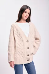 Saco de punto abierto con botones frontales, cuello en V y diseño de trenzas en relieve. Presenta puños y ruedo acanalados.