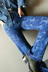Pantalón de jean de corte recto con estampado de hojas en tonos azules.