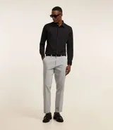 Pantalón de vestir gris claro, corte slim, con trabillas para cinturón, cierre tradicional, bolsillos laterales y traseros.