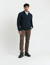 Cardigan de punto color marrón, con cuello alto y cierre frontal completo. Presenta mangas largas tipo ranglan y bolsillos laterales de ribete.