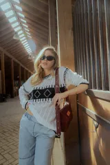 Sweater de punto calado color blanco con detalles geométricos en negro.