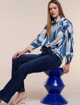 Blusa de gasa con estampado abstracto en tonos rosado, celeste, beige y negro, de silueta holgada, con cuello camisero, escote en V con media abotonadura y mangas largas de hombro caído.