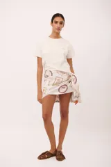 Pareo corto de tela blanca con estampado de rayas rojas y texto manuscrito.