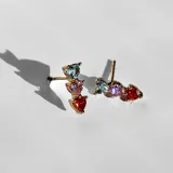 Par de aros dorados con tres cristales de colores en forma de corazón.