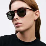 Lentes de sol Kubu modelo Tigris Olive, con montura redonda de carey y lentes polarizados color verde oscuro.