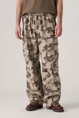 Pantalón cargo de corte amplio con estampado de camuflaje en tonos beige, marrón y verde. Cuenta con cintura elástica ajustable con cordón, bolsillos laterales con solapa y bolsillos traseros.