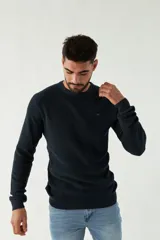 Sweater azul marino de punto con cuello redondo, mangas largas y logo bordado en el pecho.