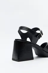 Sandalias plateadas con plataforma fina y taco ancho forrado. Incorporan pulsera con hebilla metálica y capellada ancha.