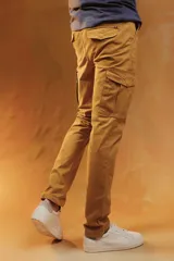 Pantalón cargo color verde militar, de corte recto y ajuste slim, con bolsillos laterales con solapa y cierre frontal.