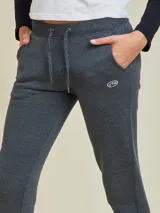 Pantalón tipo babucha de algodón y poliéster, color gris melange, con cintura elástica ajustable mediante cordón, bolsillos laterales y cierres en los tobillos.