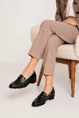 Mocasines negros de cuero con aplique grabado croco en el empeine, detalles de costuras blancas a contratapa y taco bajo.
