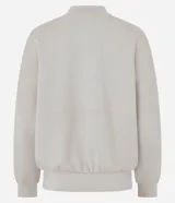 Campera bomber deportiva de mujer color beige, confeccionada en modal con cierre frontal por cremallera, cuello medio y bolsillos. Presenta mangas largas con puños elásticos y elástico en la cintura.