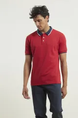 Chomba de piqué azul con cuello clásico, mangas cortas y corte recto. El cuello y los puños tienen detalles a contratono en azul marino y blanco.