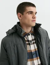 Campera Harrington de color verde oscuro, con cierre frontal de cremallera y solapa con botones a presión, cuello alto y bolsillos laterales.