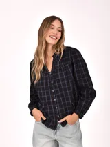 Camisa de manga tres cuartos con cuello mao y cierre frontal de botones. Presenta un diseño a cuadros en tonos oscuros con líneas finas en azul.