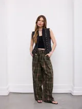 Pantalón amplio de corte relajado, con estampa a cuadros en tonos verde, negro y amarillo, cintura elástica con cordón de ajuste y bolsillos laterales.