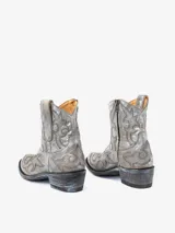 Bota texana de caña corta color gris con bordados decorativos y taco bajo.
